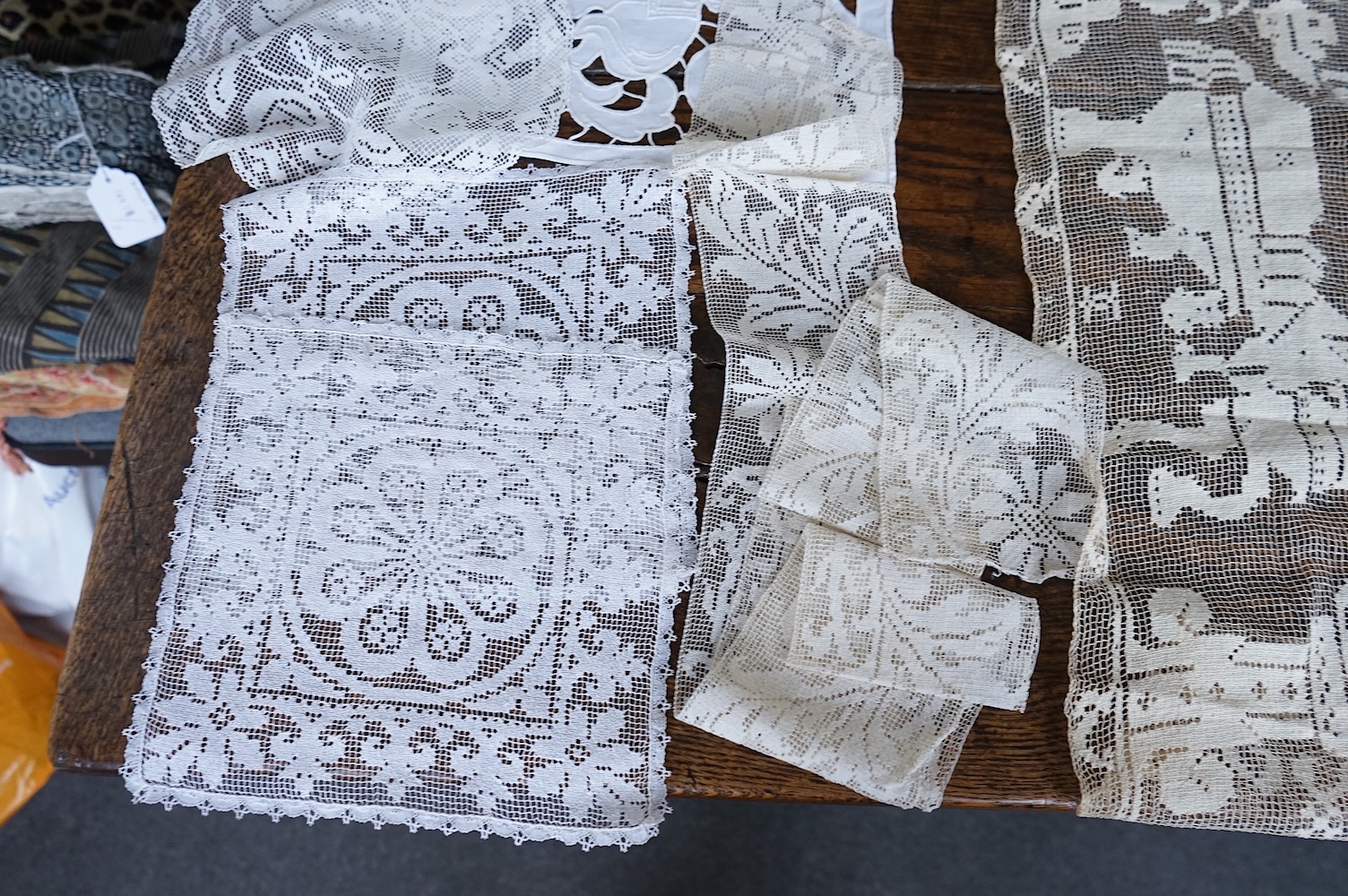 A good collection filet lace including a wide figurative elephant panel, square inserts, mats, trimming etc, with two Normandy lace mats, a cutwork mat and bobbin lace inserts.(40). Fillet panel 112cm long x 27cm wide. C